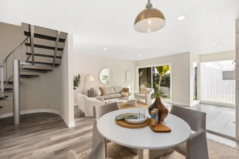 a dining room with furniture a chandelier and wooden floor