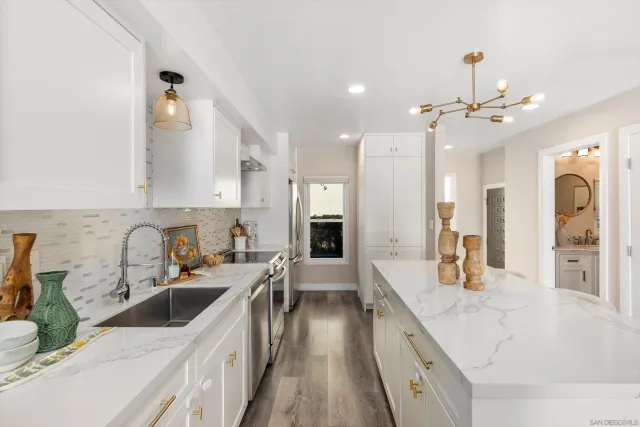 a kitchen with a sink a counter top space stainless steel appliances and a large window