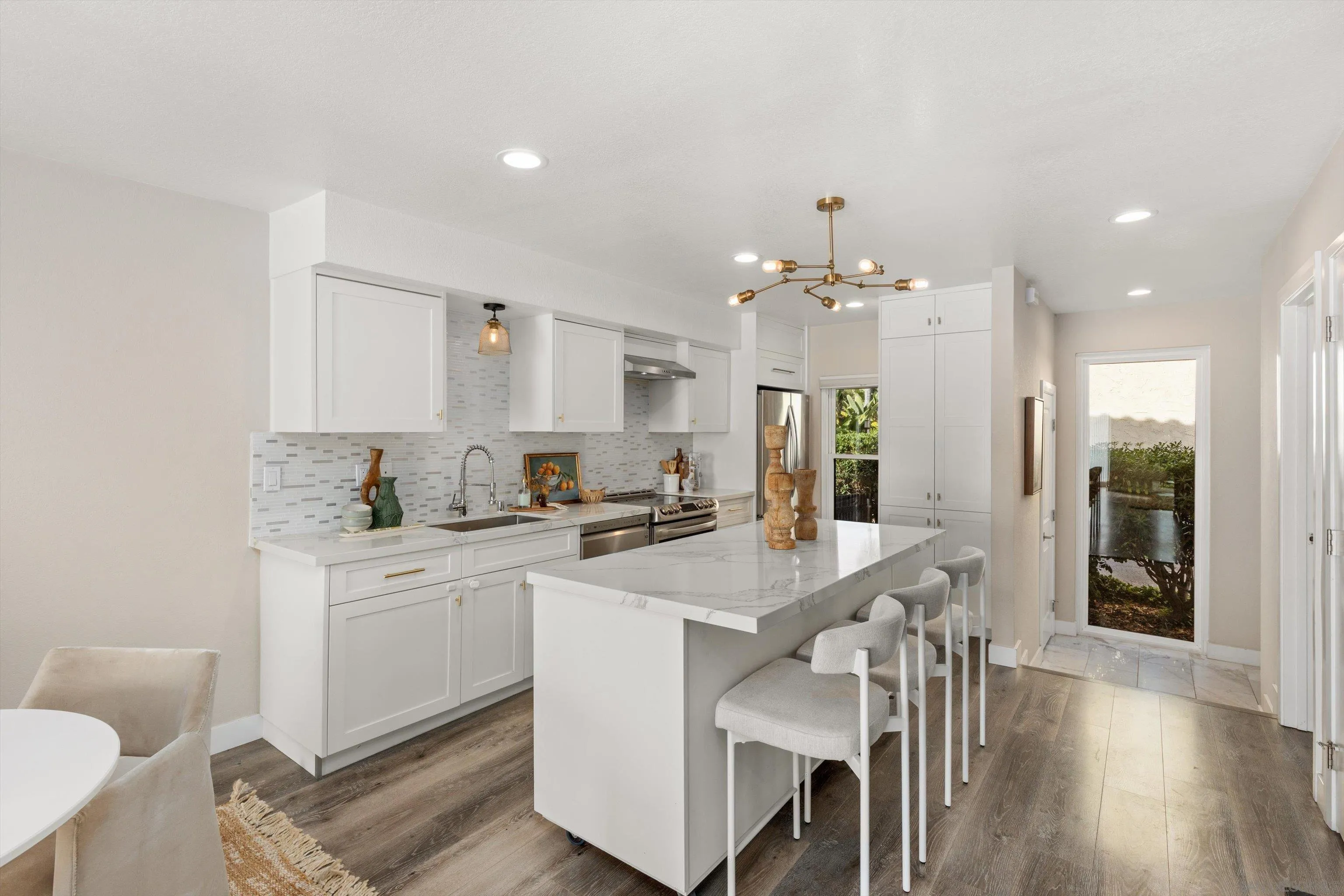 1913 Alga Road, Unit A Carlsbad, CA 92009 - Photo 6 of 44 a kitchen with a dining table chairs cabinets and stainless steel appliances