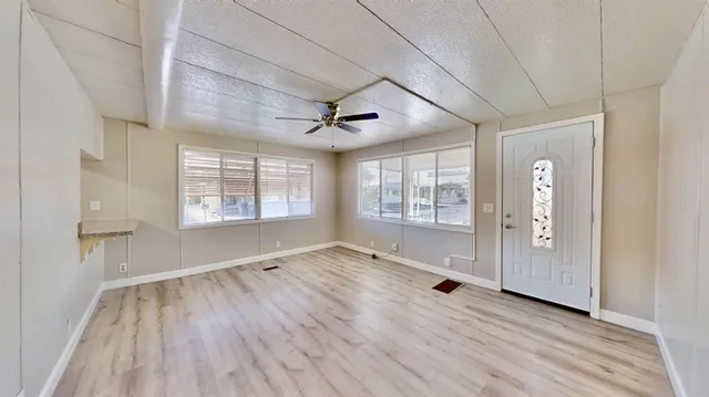 a kitchen with granite countertop a refrigerator a sink dishwasher a stove and white countertops with cabinets