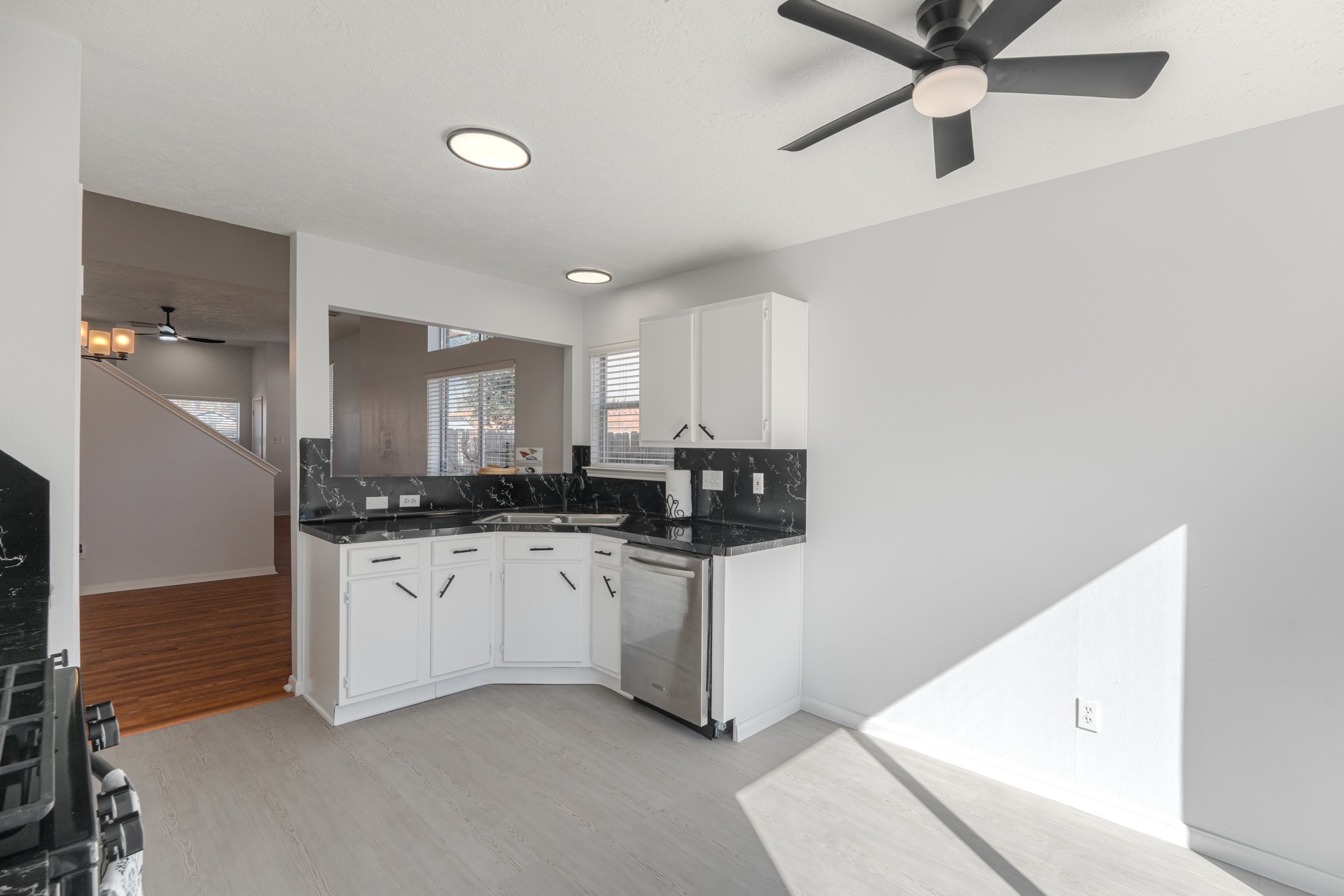 10347 Mist Lane Houston, TX 77070 - Photo 12 of 32 a kitchen with stainless steel appliances a sink dishwasher a refrigerator and white cabinets with wooden floor