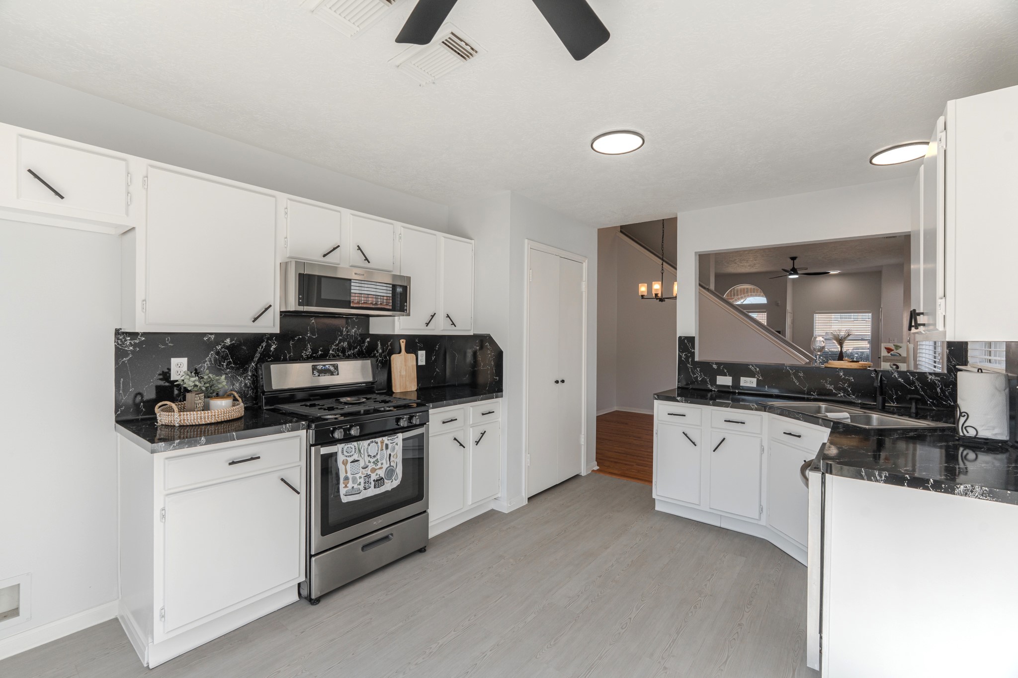 10347 Mist Lane Houston, TX 77070 - Photo 13 of 32 a kitchen with stainless steel appliances a stove sink and white cabinets