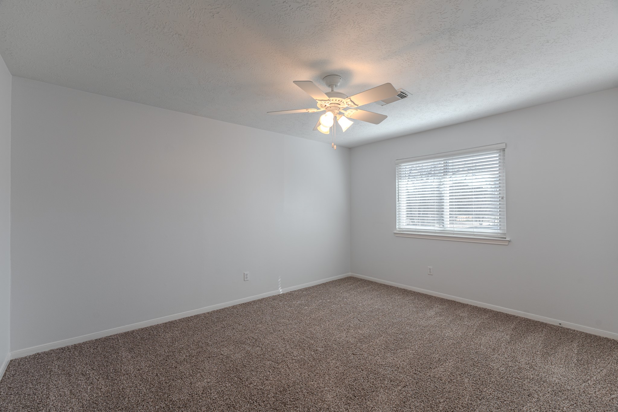 10347 Mist Lane Houston, TX 77070 - Photo 24 of 32 an empty room with a window and a fan