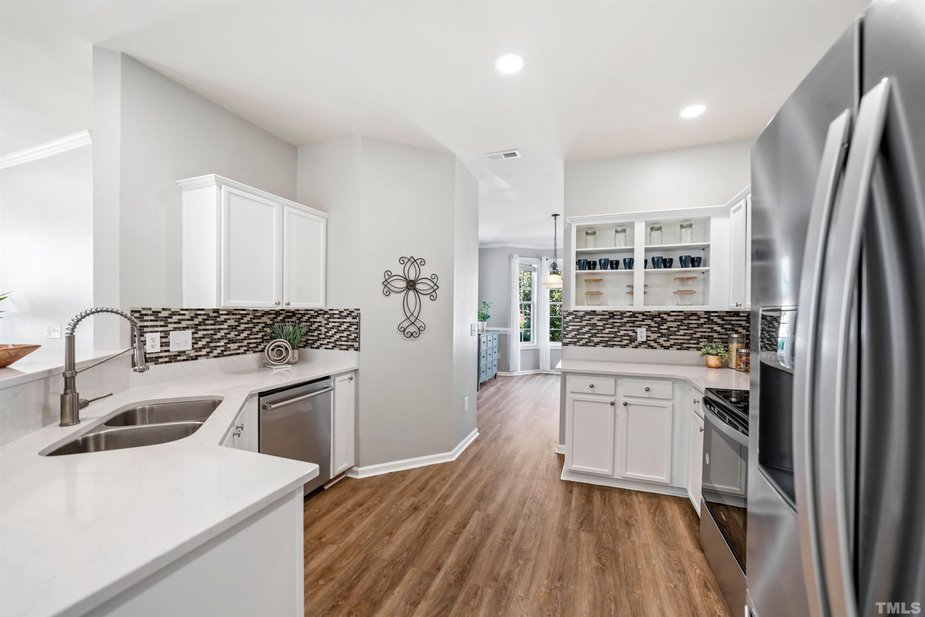 3012 White Cloud Circle Apex, NC 27502 - Photo 5 of 31 a kitchen with stainless steel appliances granite countertop a sink stove and refrigerator