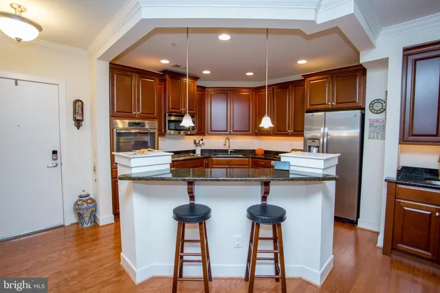 a large kitchen with kitchen island granite countertop a large counter top appliances and cabinets