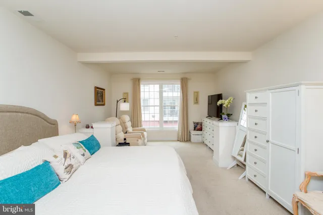 a living room with furniture a baby crib and a window
