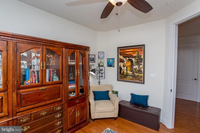 a living room with furniture a bookshelf and a window
