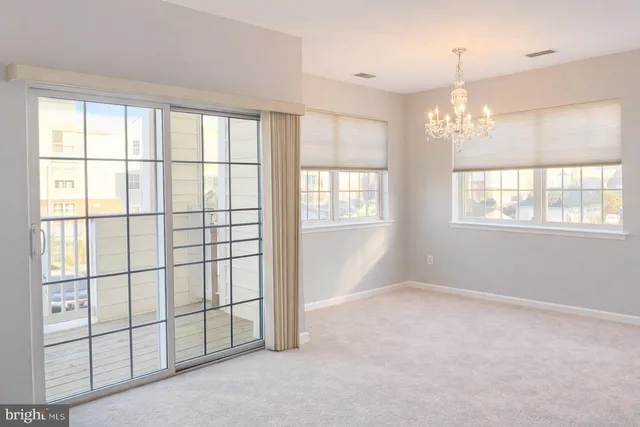 a view of a livingroom with a chandelier fan and windows