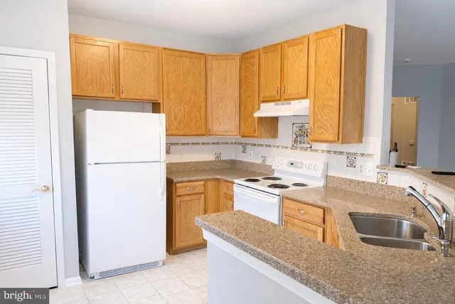 a kitchen with a sink a stove and a refrigerator