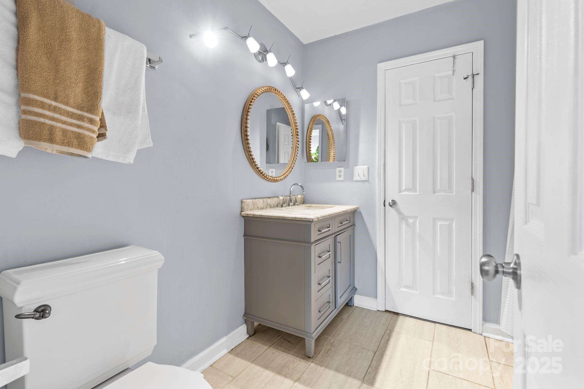 11643 Retriever Way Charlotte, NC 28269 - Photo 12 of 21 a bathroom with a sink a toilet and a mirror