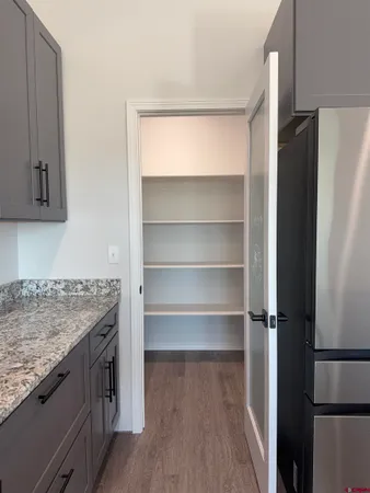 a kitchen with a refrigerator and wooden floor