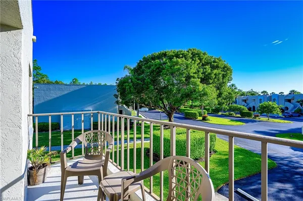 a view of a chair and tables in the balcony