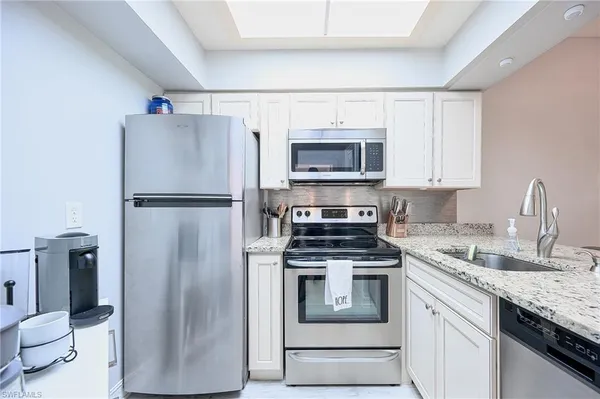 a kitchen with a refrigerator sink and microwave
