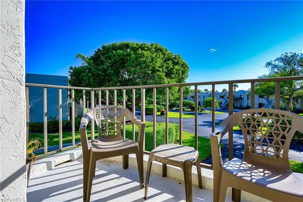 a view of a chairs and table in patio with a small yard