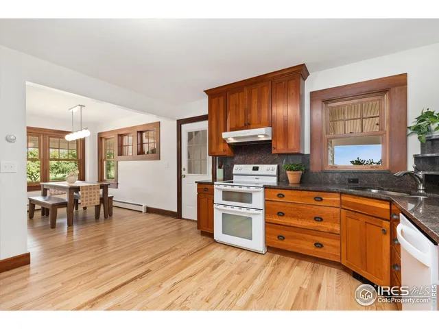 a kitchen with stainless steel appliances wooden floors and wooden cabinets