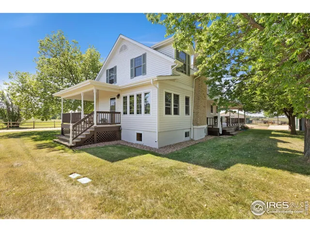 a view of an house with backyard and trees