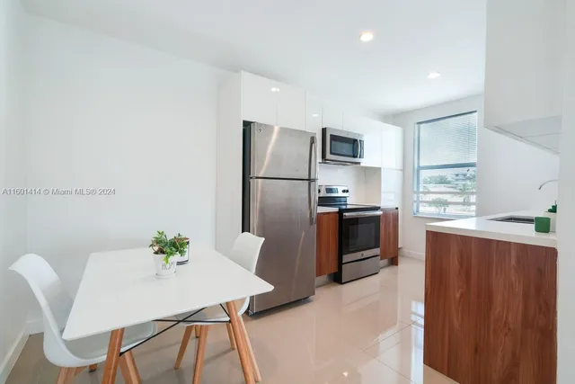 a kitchen with stainless steel appliances kitchen island a table and chairs in it