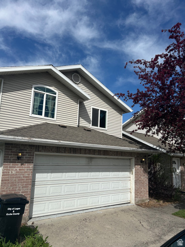 432 Spring Lane Logan, UT 84341 - Photo 2 of 22 View of front of house with brick siding, a shingled roof, driveway, and an attached garage