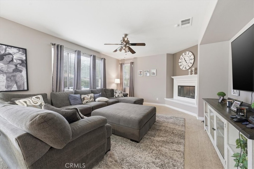 34326 Heather Ridge Road Lake Elsinore, CA 92532 - Photo 12 of 46 a living room with furniture flat screen tv and a fireplace