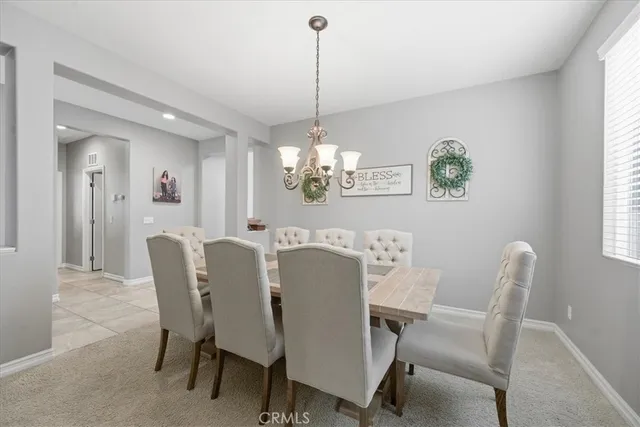 a dining room with furniture a chandelier and window