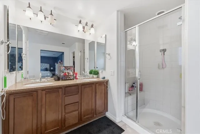a bathroom with a double vanity sink mirror and shower