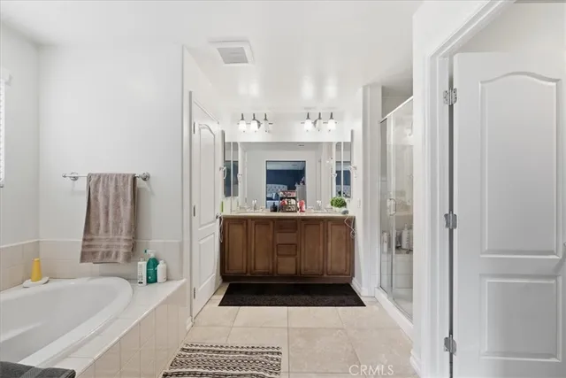a bathroom with a tub a sink and a large mirror