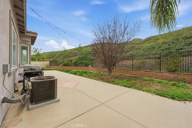 a view of backyard with barbeque grill and wooden fence