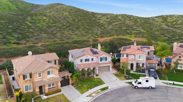 an aerial view of residential houses with outdoor space and trees