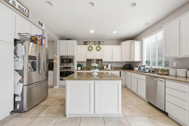 a kitchen with kitchen island cabinets and refrigerator