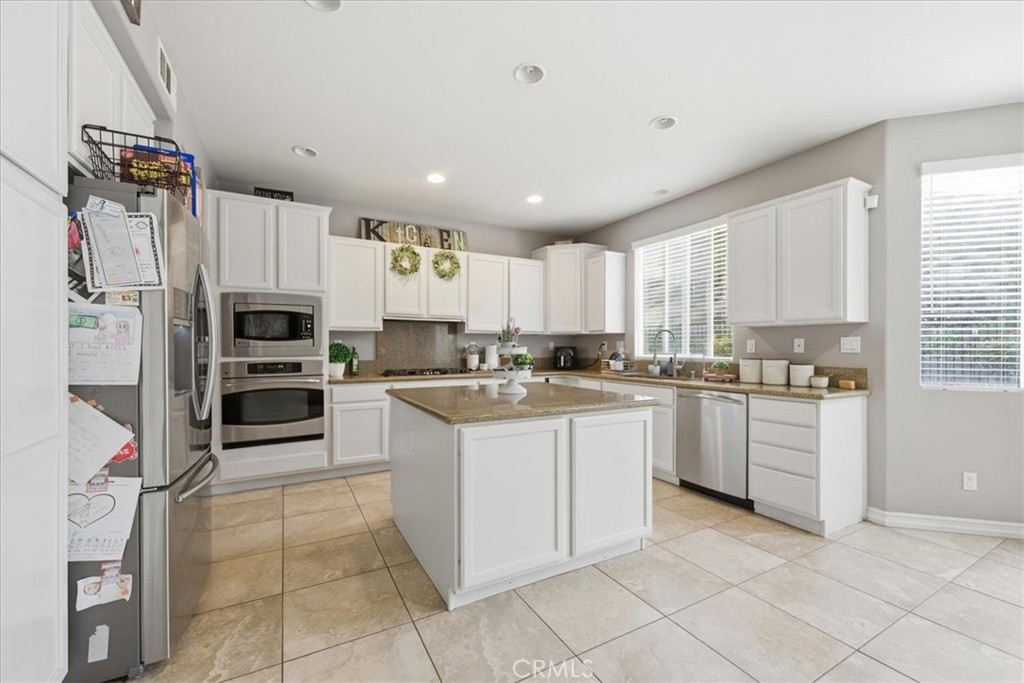 34326 Heather Ridge Road Lake Elsinore, CA 92532 - Photo 10 of 46 a large kitchen with cabinets and stainless steel appliances