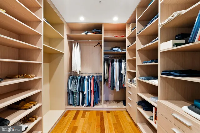 a view of walk in closet with clothes and shoes