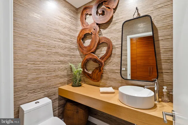 a bathroom with a toilet sink and mirror