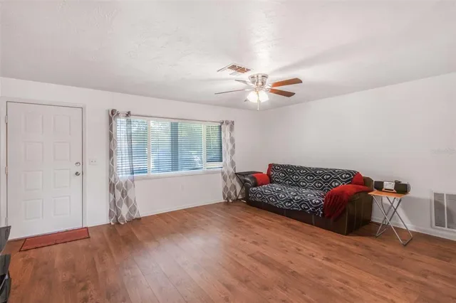 a view of livingroom with window ceiling fan and front door