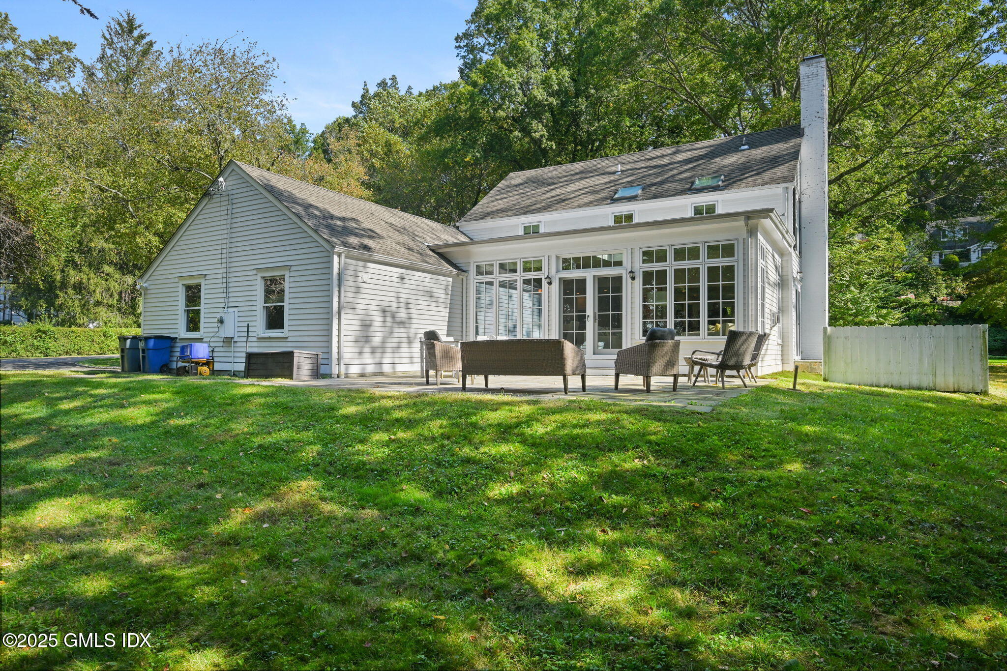 37 Ridgeview Avenue Greenwich, CT 06830 - Photo 43 of 49 a backyard of a house with table and chairs and potted plants and large tree