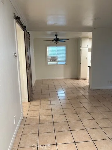an empty room with windows and a ceiling fan