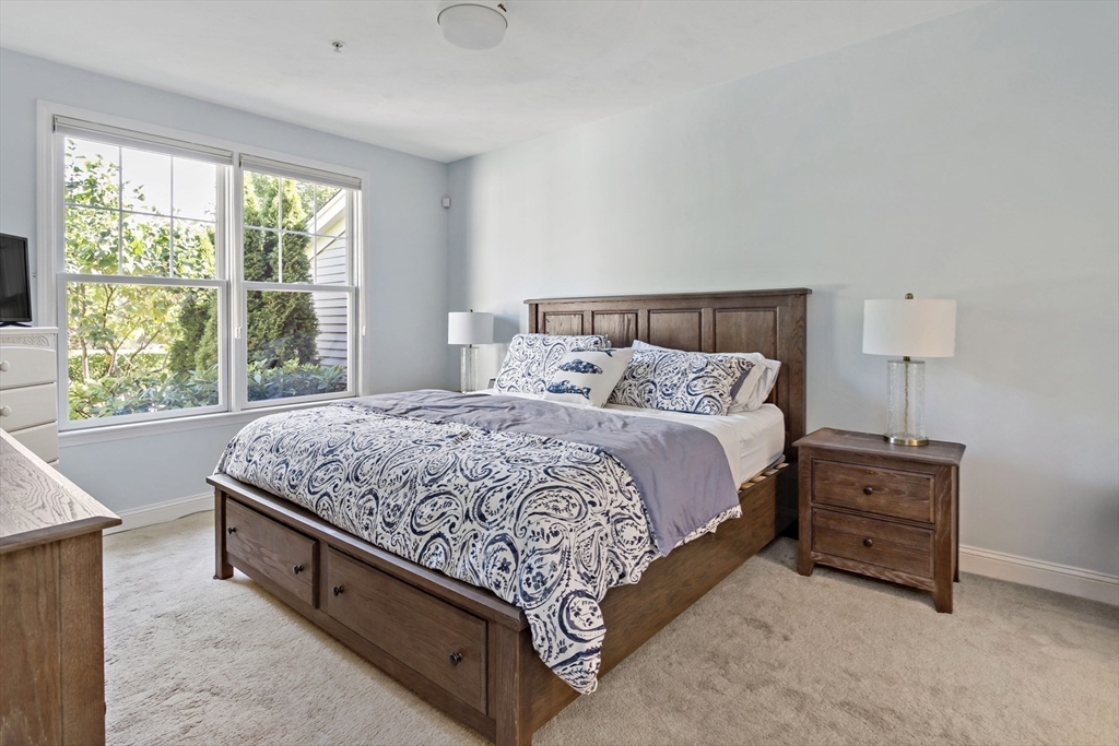23 Sea Spray Avenue, Unit 563 Mashpee, MA 02649 - Photo 20 of 39 a spacious bedroom with a bed and a window