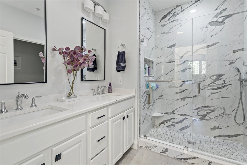 23 Sea Spray Avenue, Unit 563 Mashpee, MA 02649 - Photo 21 of 39 a bathroom with a double vanity sink mirror and shower