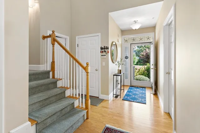 a view of a hallway with wooden floor and staircase
