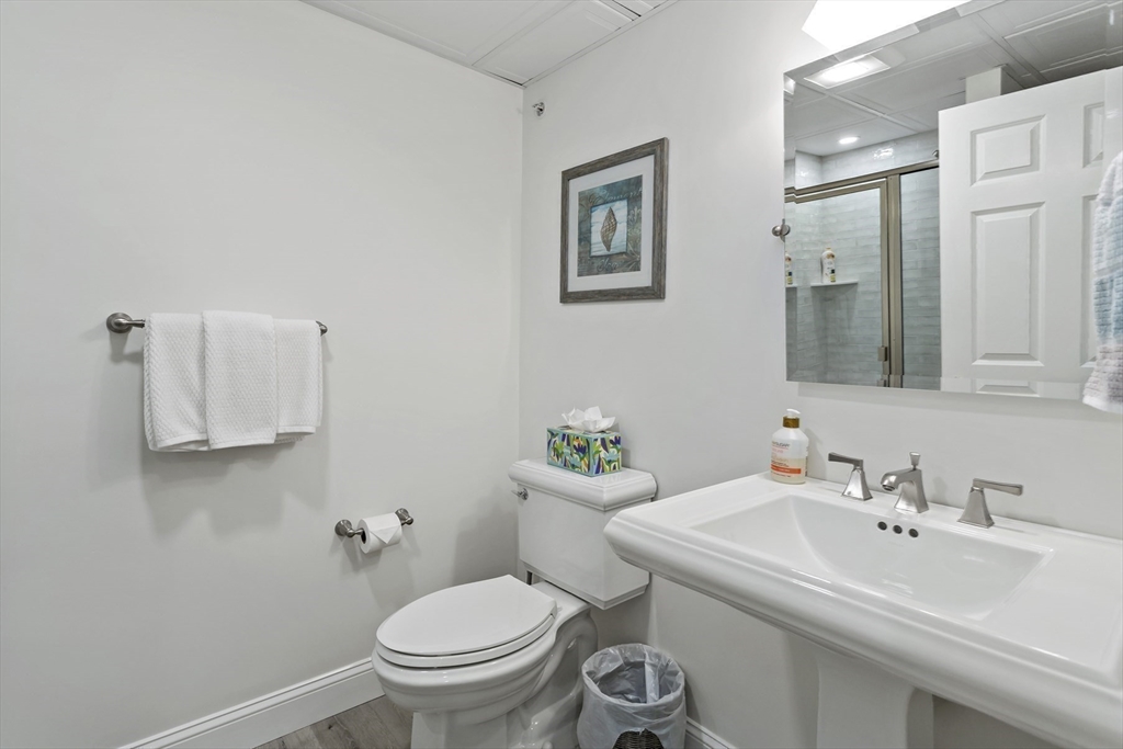 23 Sea Spray Avenue, Unit 563 Mashpee, MA 02649 - Photo 33 of 39 a bathroom with a sink toilet and a mirror
