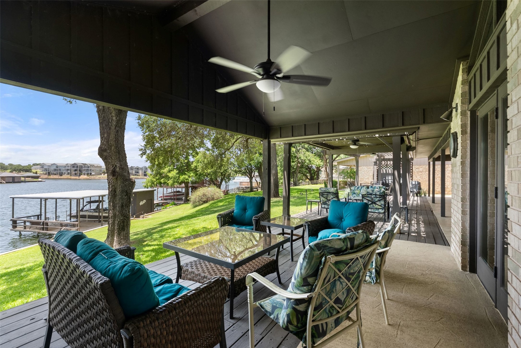 141 Perry Lane Kingsland, TX 78639 - Photo 26 of 40 A spacious covered patio invites relaxation with lake views and lush green surroundings.
