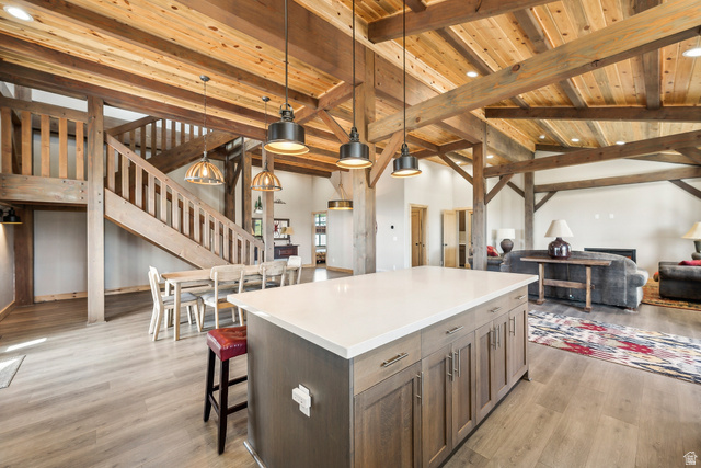 46997 West Thunder Road Fruitland, UT 84027 - Photo 49 of 49 Kitchen with hanging light fixtures, open floor plan, a wood ceiling with exposed beams, a center island, and light wood-type flooring