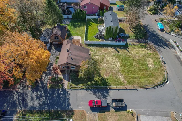an aerial view of a house with swimming pool and large trees