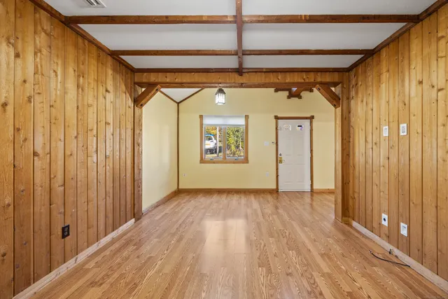a view of a hallway with wooden floor and door