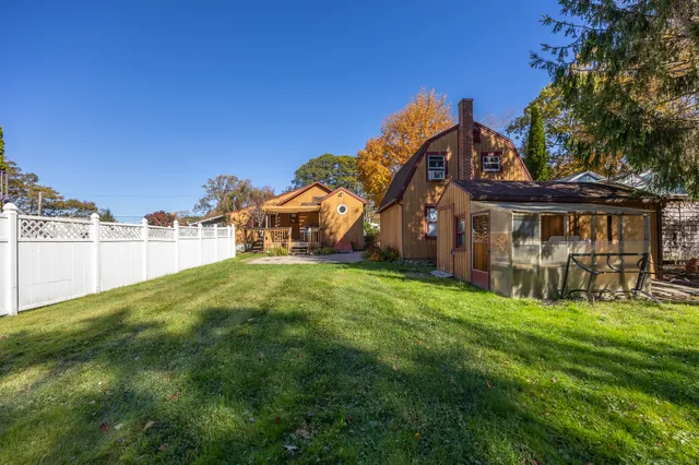a view of a house with a big yard and large trees
