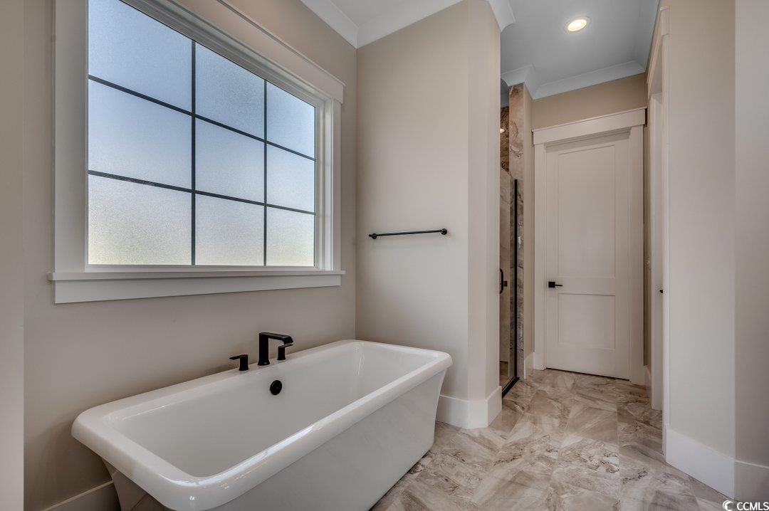 404 Plantation Oaks Drive Myrtle Beach, SC 29579 - Photo 10 of 29 Full bathroom featuring marble tiled flooring, baseboards, a shower stall, a freestanding bath, and crown molding
