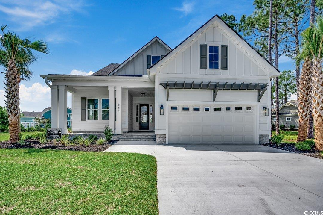 404 Plantation Oaks Drive Myrtle Beach, SC 29579 - Photo 2 of 29 Modern inspired farmhouse with board and batten siding, covered porch, a front lawn, and driveway