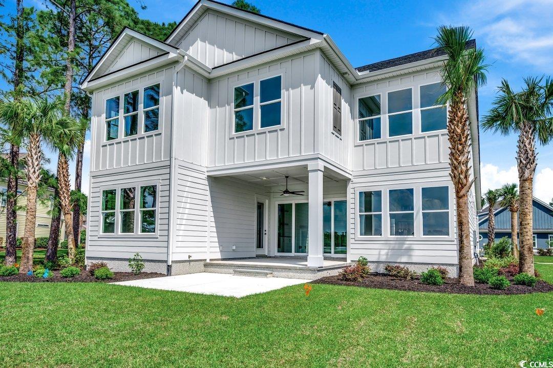 404 Plantation Oaks Drive Myrtle Beach, SC 29579 - Photo 23 of 29 Rear view of house featuring board and batten siding, ceiling fan, a yard, and a patio