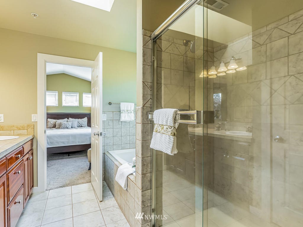 2019 Northeast 9th Court, Unit A Renton, WA 98056 - Photo 15 of 26 a bathroom with a tub a mirror and a shower