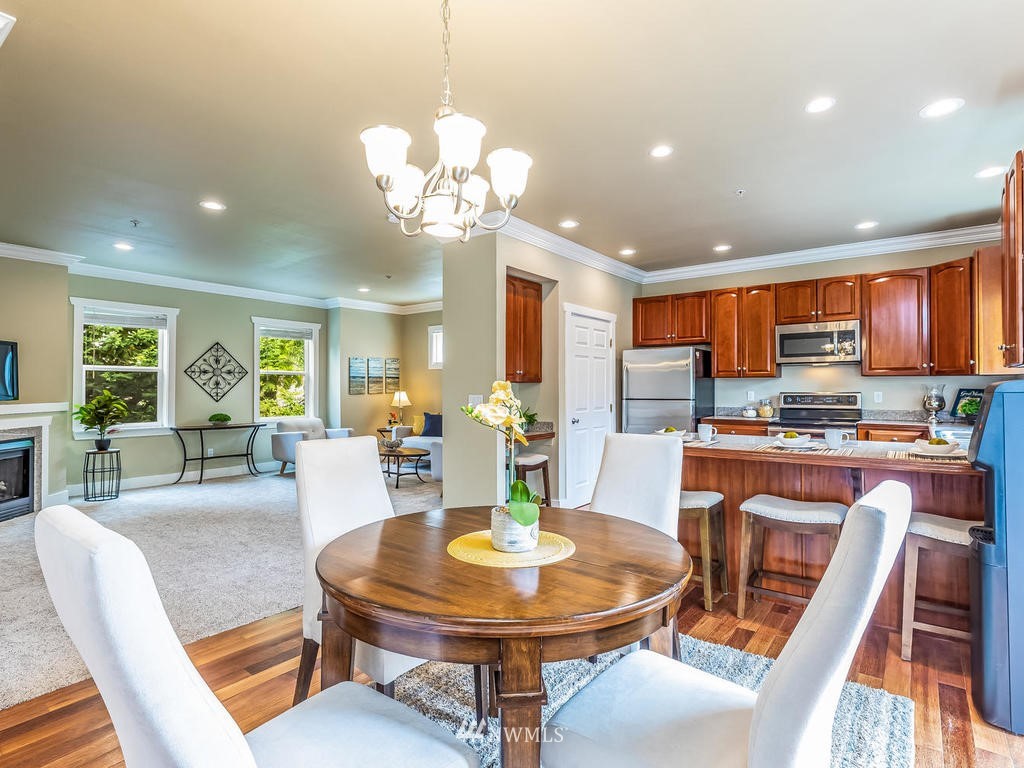 2019 Northeast 9th Court, Unit A Renton, WA 98056 - Photo 7 of 26 a view of a dining room with furniture a kitchen and chandelier