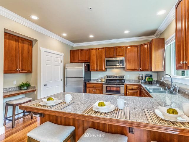 a kitchen with a dining table chairs and refrigerator